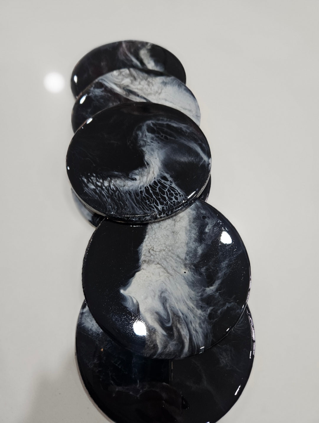 Set of hand-poured resin coasters by Art by Rafaela in deep black with swirling white — one of a kind coastal homewares