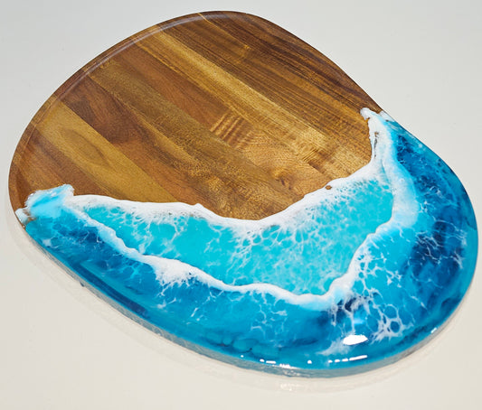 Hand-poured resin oval platter by Art by Rafaela with turquoise and aqua ocean waves on natural hardwood grain — coastal entertaining